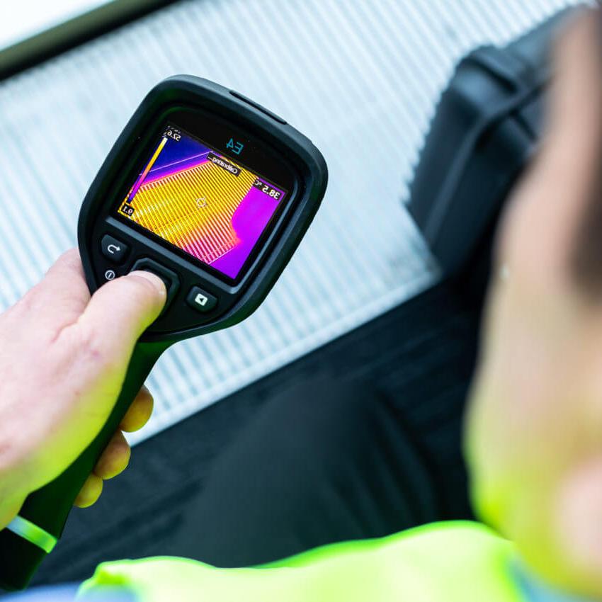 Worker using a handheld temperature sensor